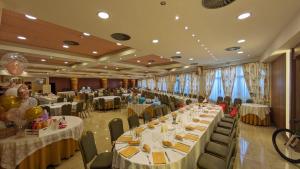 un salón de banquetes con mesas y sillas largas en Hotel Villa de Larraga, en Larraga