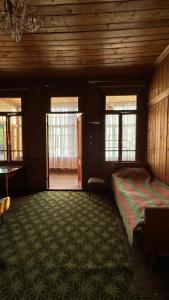 1 dormitorio con cama y alfombra grande en Wood House Gomi, en Ozurgetʼi