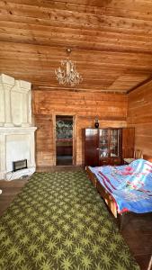 1 dormitorio con cama y lámpara de araña en Wood House Gomi, en Ozurgetʼi