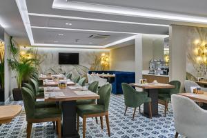 un restaurant avec des tables en bois et des chaises vertes dans l'établissement Rayelin Hotel Istanbul Old City Special Category, à Istanbul
