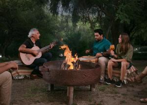 a group of people sitting around a fire pit at Posada Rural La Matilde in San Javier