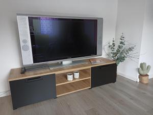 a flat screen tv sitting on top of a wooden entertainment center at Ferienwohnung Erftalblick in Hardheim