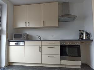 a kitchen with white cabinets and a microwave at Ferienwohnung Erftalblick in Hardheim