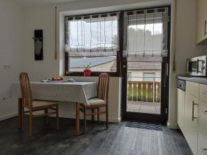 a kitchen with a table and chairs and a window at Ferienwohnung Erftalblick in Hardheim +5 photos
