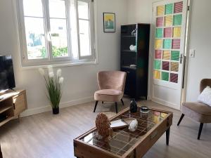 ein Wohnzimmer mit Couchtisch und Stühlen in der Unterkunft Ker LN in Saint-Nazaire