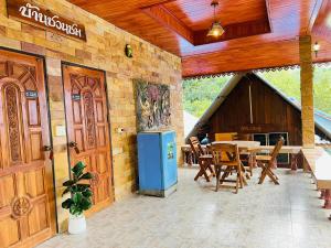 an outdoor patio with a table and a blue refrigerator at Adventure Point Resort By Sali in Kaeng Krachan