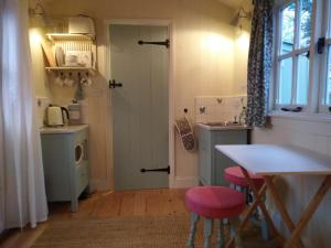 ウスターにあるThe Shepherd's Hut at Beechcroftのキッチン(シンク、テーブル、椅子付)