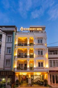 a white hotel with a sign on top of it at CHERRY HOTEL in Da Lat