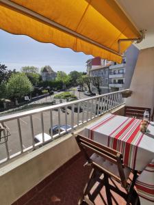 a table and chair on a balcony with a view of a street at Studio Sunset Biarritz in Biarritz