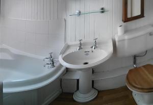 a white bathroom with a sink and a toilet at Airebroc House in Uig