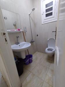łazienka z umywalką, toaletą i oknem w obiekcie شقة 2 غرفة بتكييف w mieście Marsa Matruh