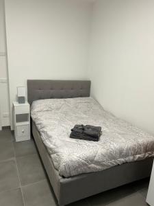 czarna torba siedząca na łóżku w pokoju w obiekcie Casa Canova - private room in sharing apartment w Trydencie