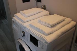 a stack of towels sitting on top of a washing machine at La Luna Blu Malpensa appartamento Papaveri in Somma Lombardo