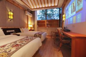 um quarto de hotel com duas camas e uma secretária em Mild Spring Boutique Hotel em Huangshan
