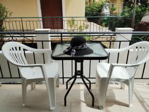 a black hat sitting on a table with two chairs at Nikos Apartments 3 in Kavos