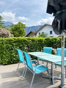 a table and chairs on a deck with an umbrella at Ferienwohnung Nusslberg in Kiefersfelden