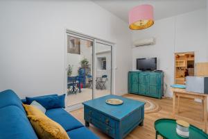 een woonkamer met een blauwe bank en een tafel bij Duplex 4 pers. centre avec cour privée ensoleillée in Marseille