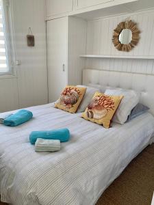uma grande cama branca com almofadas em cima em Villa L'Amiraute em Agde
