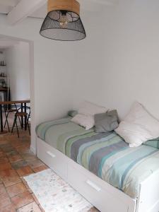 a bed in a room with a white wall at Studio Versailles Woods in Jouy-en-Josas