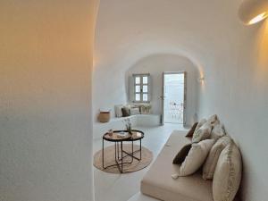 a white living room with a couch and a table at as holiday caves in Mesaria