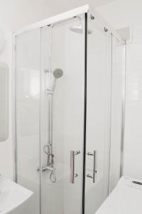 a shower with a glass door in a bathroom at Saska Kępa Luxe Apartment in Warsaw +6 photos