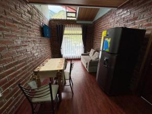 a living room with a table and a brick wall at Cabaña Mirador in Pititic