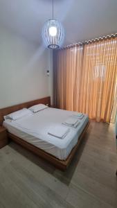 a bedroom with a large bed with a chandelier at Palase GC 141 in Palasë +10 photos
