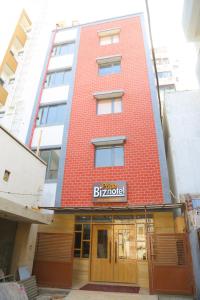 a red brick building with a sign on it at Hotel Nova Pride in Rajkot