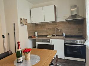 Miuti Residence في تيبرغ: مطبخ مع طاولة مع زجاجة من النبيذ