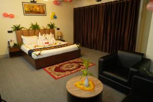 a bedroom with a bed and a couch and a chair at Nitol Bay Resort in Cox's Bazar
