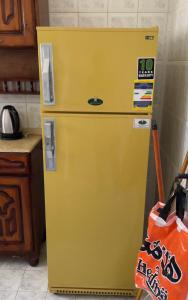 a yellow refrigerator with a sign on it in a kitchen at شاليه مرسي مطروح قرية السعودية in Marsa Matruh
