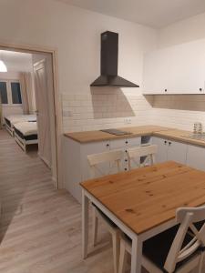 a kitchen with a wooden table and a dining room at Bajkowy Las in Pobierowo