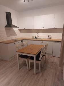 a kitchen with a wooden table and chairs at Bajkowy Las in Pobierowo