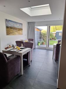 a dining room with a table and chairs at B&B Marijke in De Koog