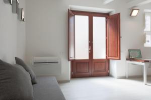 ein Wohnzimmer mit einer Tür und einem Fenster in der Unterkunft ALIMENTA open space city center in Lucca