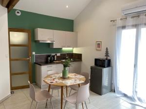 uma cozinha com uma mesa e cadeiras numa cozinha em Appartement 2 à 4 personnes, Une Pause au Vert em Châteauvieux