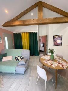 een woonkamer met een bank en een tafel bij Appartement 2 à 4 personnes, Une Pause au Vert in Châteauvieux