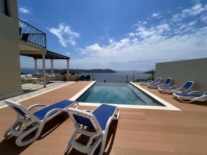 オラサックにあるVilla Judita Dubrovnikのスイミングプールの隣のデッキに座る椅子