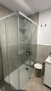 una cabina doccia in vetro in un bagno con uno sgabello di Pizarro 23, en el corazón de Cáceres a Cáceres Altre 12 foto