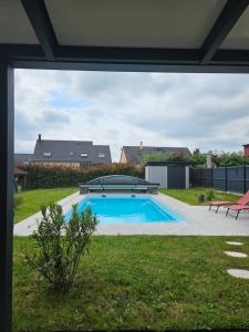a large swimming pool in a yard with a patio at Idéal 24H voiture, moto, camion in Mulsanne