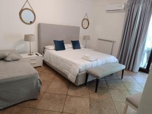 sypialnia z 2 łóżkami z niebieskimi poduszkami i krzesłem w obiekcie B & B Villa Flora w mieście Mondello