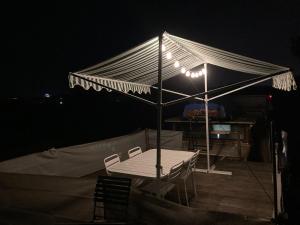 uma mesa e cadeiras debaixo de uma tenda à noite em Le logement du marinier em Eckwersheim
