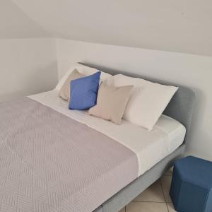 a bed with white and blue pillows on it at Gate 25 in San Giovanni Teatino