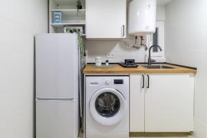 a kitchen with a washing machine and a refrigerator at Acogedor apartamento céntrico in Santander