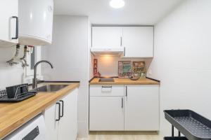 a kitchen with white cabinets and a sink at Acogedor apartamento céntrico in Santander