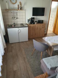 a kitchen with a counter and a table and a table and chair at FeWo Inselzeit in Ueckeritz