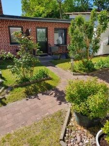 een tuin met een stenen huis met een loopbrug bij FeWo Inselzeit in Ueckeritz