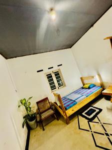 a bedroom with a bed and a chair in a room at Madiha Hostel by Land of Rizka in Matara