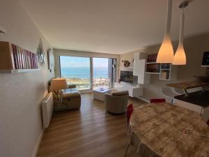 ein Wohnzimmer mit einem Tisch und Meerblick in der Unterkunft RÉF 319 - PLOEMEUR Lomener bel appartement T3 balcon vue mer avec ascenseur in Ploemeur