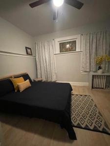 - une chambre avec un lit noir et un ventilateur de plafond dans l'établissement Suite Dream Clifton 27, à Clifton